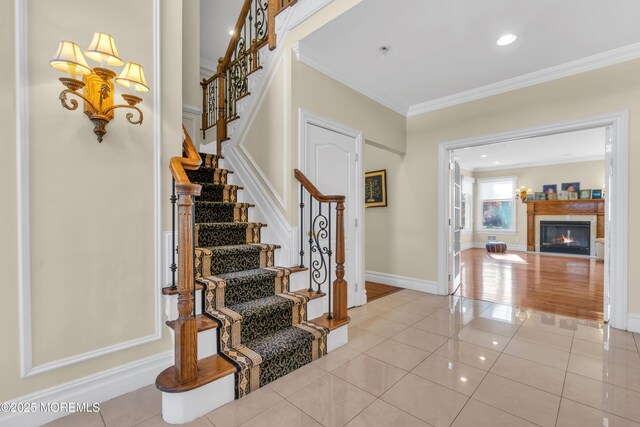 208 Imperial Ct, Lakewood, NJ 08701 - entrance foyer with ornamental molding, light tile patterned floors, stairway, a fireplace with flush hearth, and recessed lighting