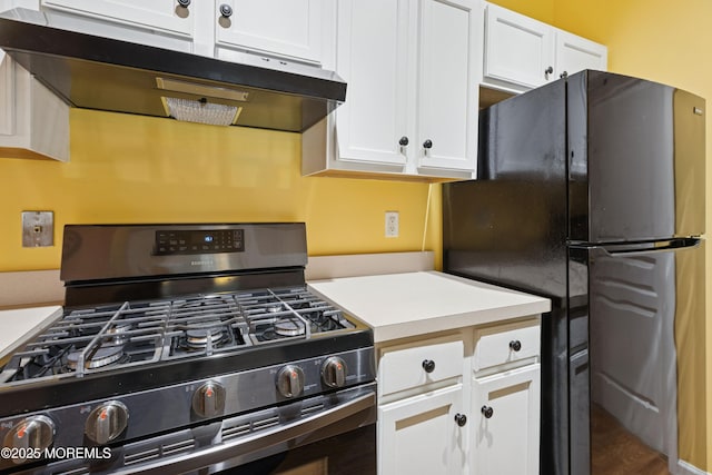 2015 Whitcomb Rd, Forked River, NJ 08731 - kitchen with under cabinet range hood, gas stove, freestanding refrigerator, white cabinetry, and light countertops