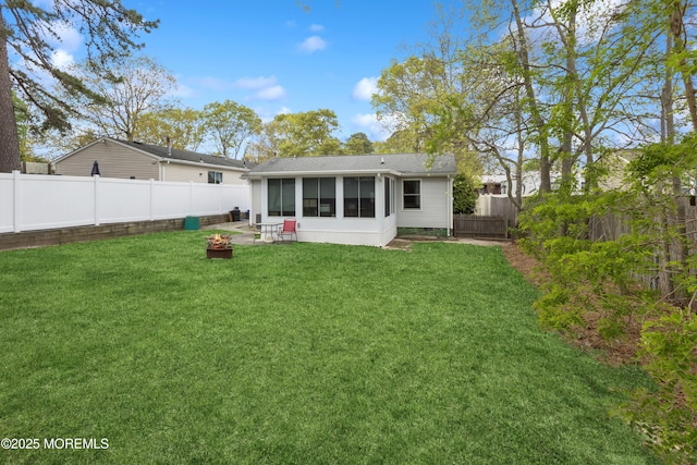2015 Whitcomb Rd, Forked River, NJ 08731 - rear view of house featuring a sunroom, a fenced backyard, an outdoor fire pit, and roof with shingles