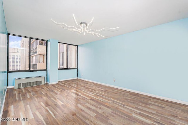 200 Winston Dr Unit 2921, Cliffside Park, NJ 07010 - spare room with a chandelier, wood finished floors, and radiator heating unit