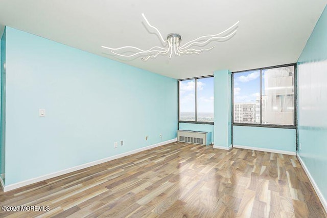 200 Winston Dr Unit 2921, Cliffside Park, NJ 07010 - unfurnished room with wood finished floors, a chandelier, and radiator heating unit