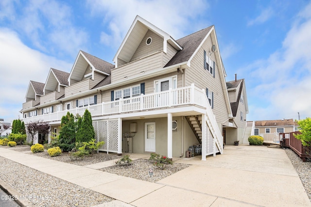 1301 SW Central Ave Unit A3, Seaside Park, NJ 08752 - view of front facade with stairway, a shingled roof, concrete driveway, and a deck