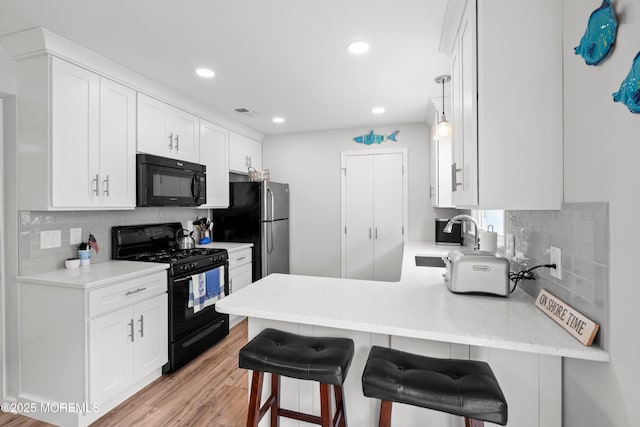 1301 SW Central Ave Unit A3, Seaside Park, NJ 08752 - kitchen with black appliances, a peninsula, white cabinetry, decorative backsplash, and recessed lighting