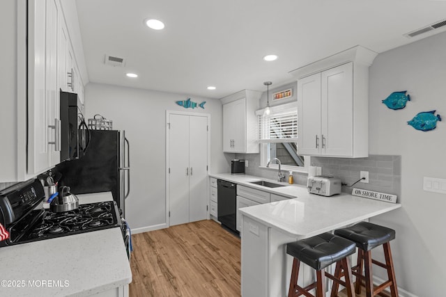 1301 SW Central Ave Unit A3, Seaside Park, NJ 08752 - kitchen featuring black appliances, decorative backsplash, light wood-type flooring, white cabinetry, and a peninsula