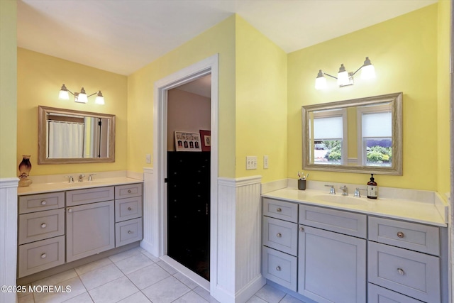 708 Lyman Ave, Brielle, NJ 08730 - full bathroom with two vanities, tile patterned flooring, and a wainscoted wall