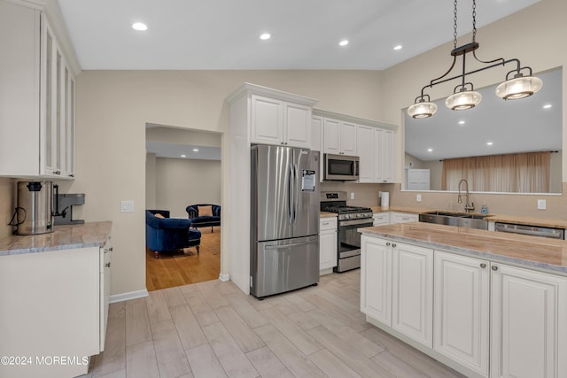 222 Bartley Rd, Jackson, NJ 08527 - kitchen featuring stainless steel appliances, white cabinetry, vaulted ceiling, light stone counters, and light wood finished floors