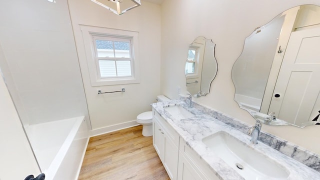 bathroom featuring vanity, toilet, a bathing tub, and hardwood / wood-style floors