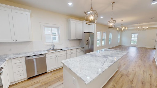 kitchen featuring white cabinetry, stainless steel appliances, a center island, and sink