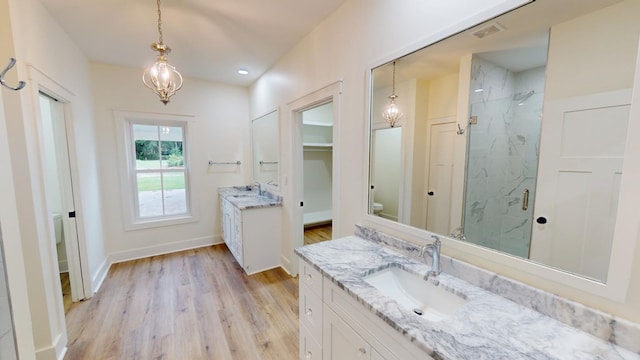 bathroom featuring walk in shower, toilet, an inviting chandelier, vanity, and hardwood / wood-style flooring