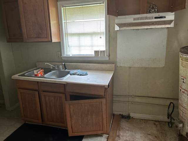 606 Willard Ave, Albany, GA 31701 - kitchen featuring brown cabinetry, a sink, gas water heater, and light countertops
