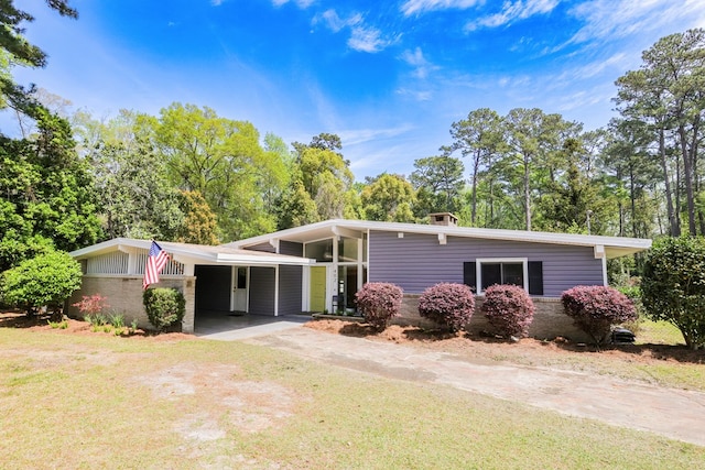 mid-century inspired home with driveway, a carport, and a front lawn