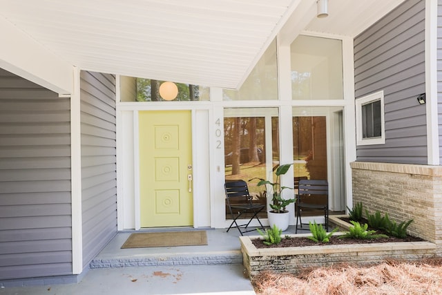 entrance to property featuring brick siding
