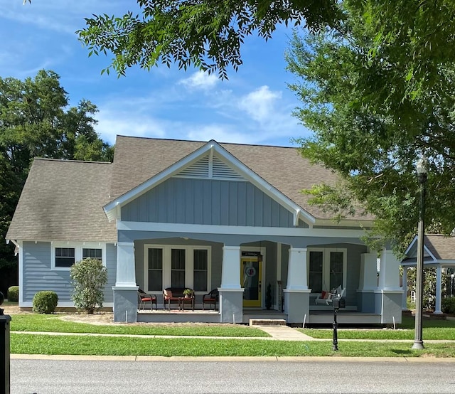 back of house featuring a porch and a yard