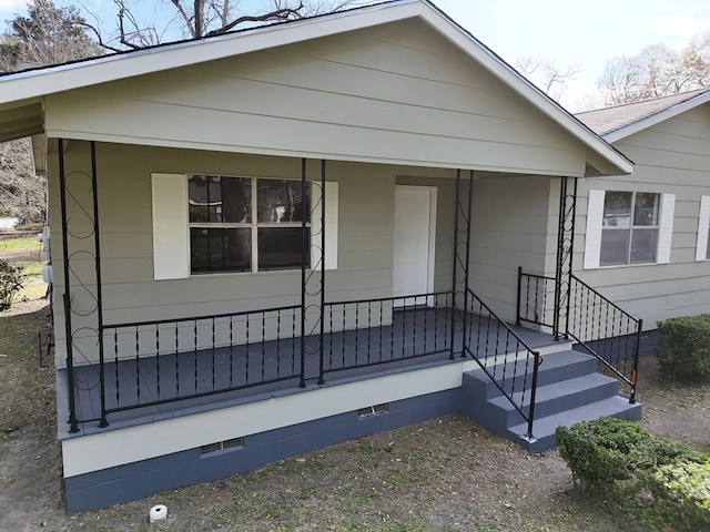 view of front of home with a porch and crawl space