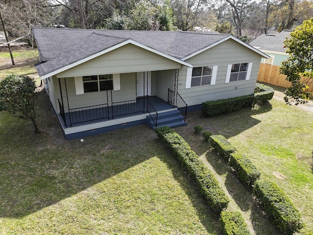 ranch-style house with driveway, a shingled roof, fence, and a porch