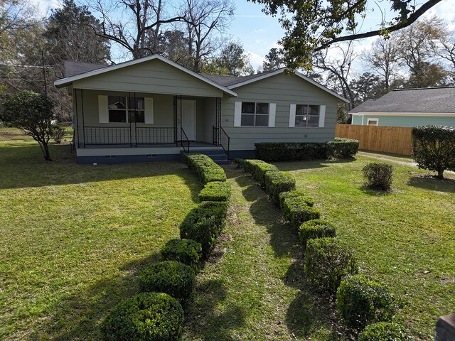 view of front of house featuring fence, a front lawn, and a porch