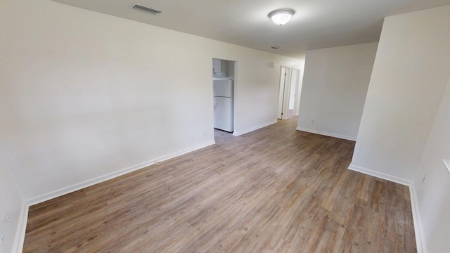 unfurnished room featuring light wood-style floors, baseboards, and visible vents