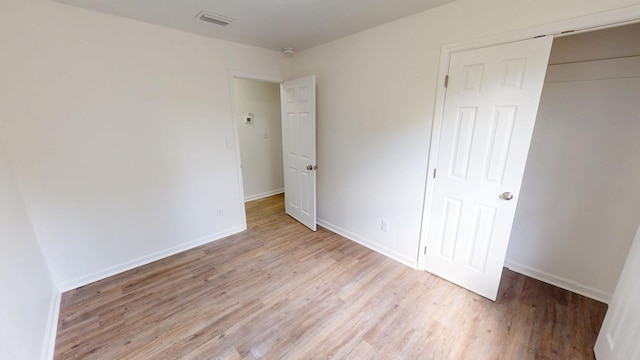 unfurnished bedroom featuring light wood-style flooring, visible vents, and baseboards