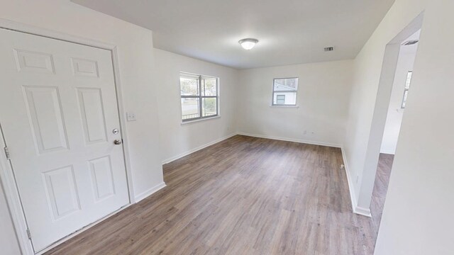 interior space featuring baseboards, visible vents, and wood finished floors