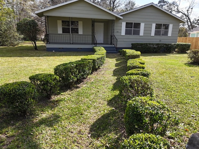 view of front of property featuring crawl space, covered porch, fence, and a front yard