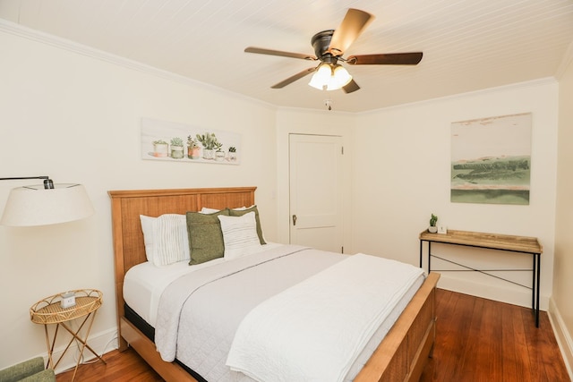 bedroom featuring baseboards, a ceiling fan, wood finished floors, and crown molding