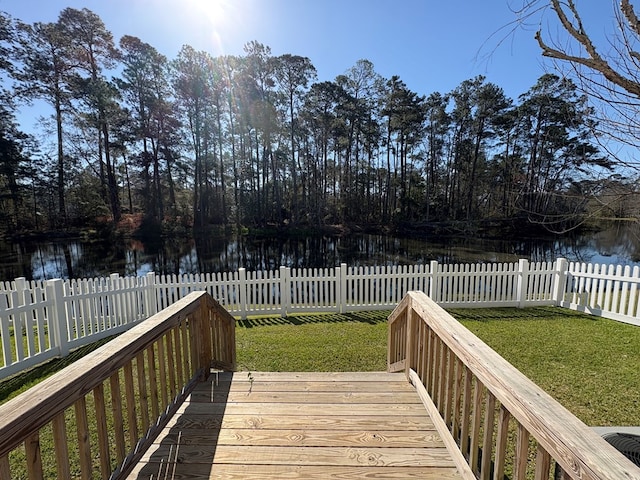 wooden deck with a lawn, fence private yard, and a water view