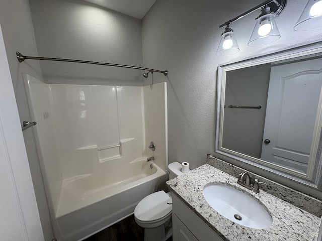 full bathroom featuring vanity, toilet, a textured wall, and shower / washtub combination