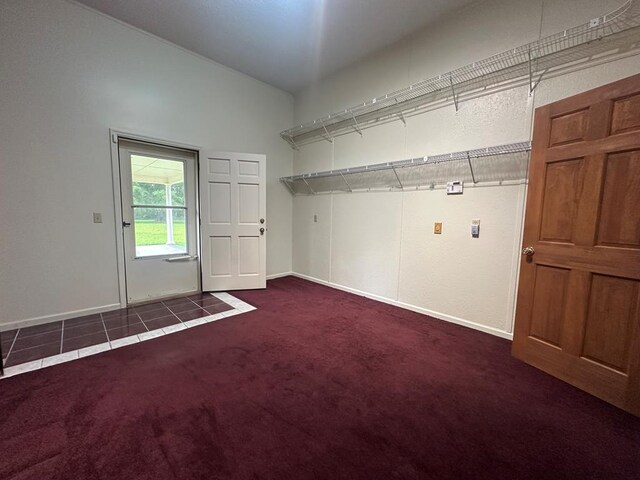 clothes washing area with dark colored carpet and baseboards