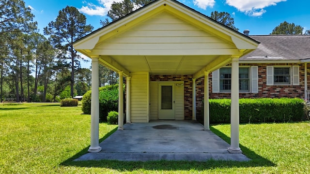 view of front facade with brick siding, a front yard, and a carport
