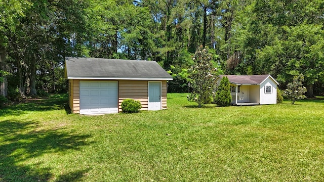 view of grassy yard with an outdoor structure and a detached garage