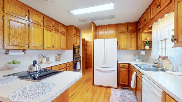 kitchen with black appliances, a sink, and light countertops
