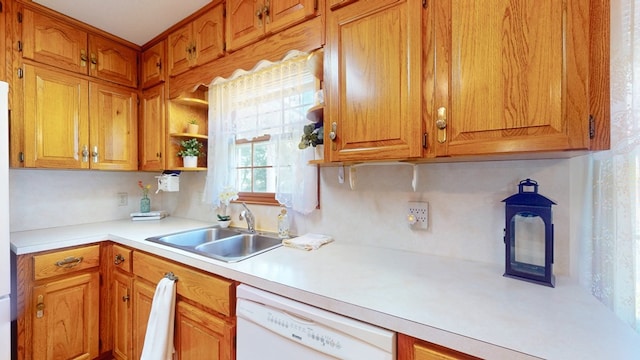kitchen with white dishwasher, a sink, light countertops, and brown cabinetry