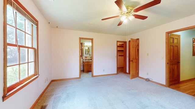 unfurnished bedroom with light colored carpet, multiple windows, and baseboards