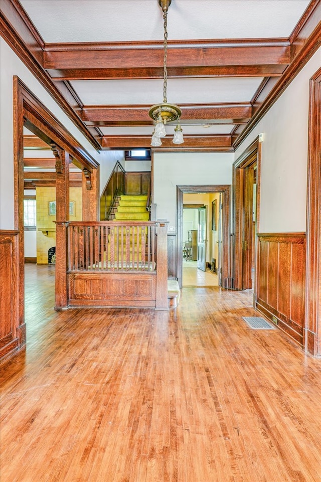 902 SE 2nd St, Moultrie, GA 31776 - empty room with wood finished floors, stairs, beam ceiling, wainscoting, and a chandelier