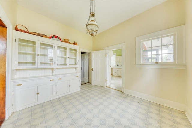 902 SE 2nd St, Moultrie, GA 31776 - unfurnished dining area with light floors, baseboards, a chandelier, and vaulted ceiling