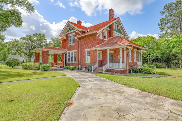 902 SE 2nd St, Moultrie, GA 31776 - view of front of home with covered porch, a chimney, brick siding, and a front lawn