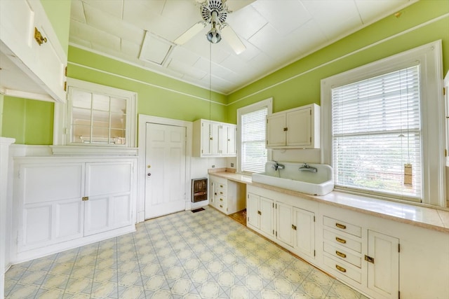 902 SE 2nd St, Moultrie, GA 31776 - kitchen featuring a sink, heating unit, ceiling fan, light flooring, and light countertops