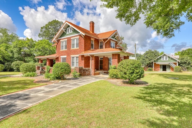 902 SE 2nd St, Moultrie, GA 31776 - view of front facade with brick siding, a chimney, covered porch, and a front yard