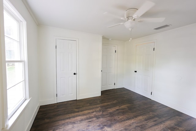 101 Hambleton St, Thomasville, GA 31792 - unfurnished bedroom featuring dark wood-style flooring, multiple windows, ceiling fan, ornamental molding, and a closet