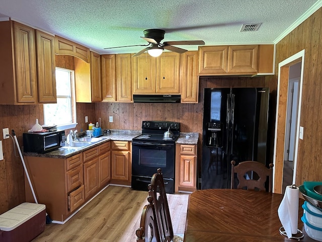 kitchen featuring sink, ceiling fan, black appliances, light hardwood / wood-style floors, and a textured ceiling