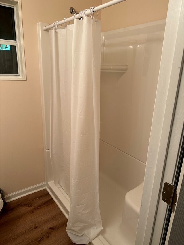 bathroom with hardwood / wood-style flooring and a shower with curtain