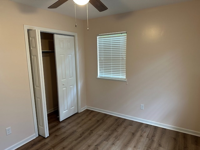 unfurnished bedroom with ceiling fan, dark hardwood / wood-style flooring, and a closet