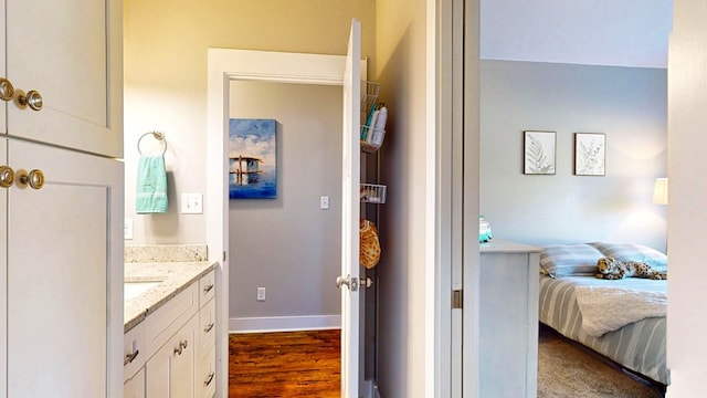 bathroom featuring vanity, wood finished floors, and baseboards