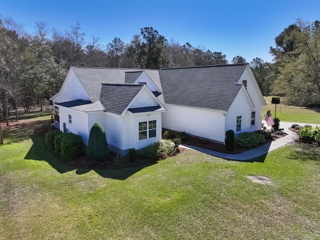 view of property exterior featuring a lawn and a shingled roof