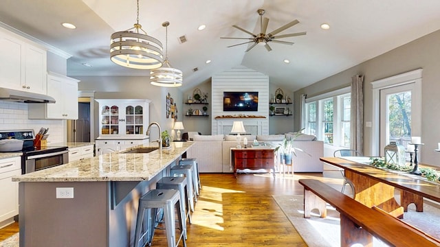 kitchen with ceiling fan with notable chandelier, a sink, under cabinet range hood, white cabinetry, and stainless steel electric range