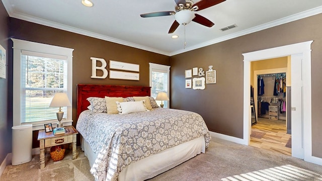 carpeted bedroom with visible vents, a walk in closet, baseboards, ornamental molding, and recessed lighting