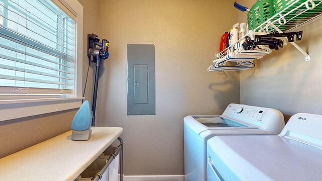 washroom featuring electric panel, separate washer and dryer, and laundry area