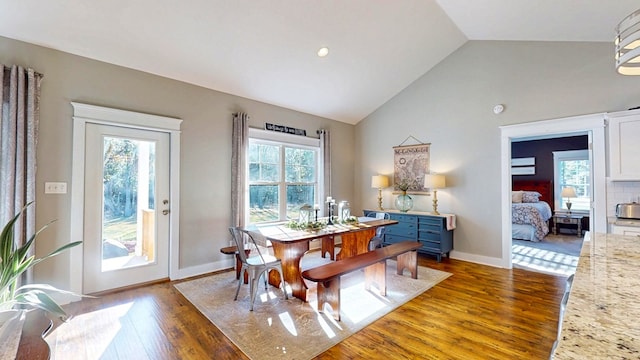 dining space with baseboards, lofted ceiling, and wood finished floors