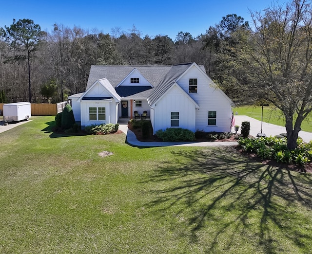 view of front of house featuring a front yard, fence, and board and batten siding