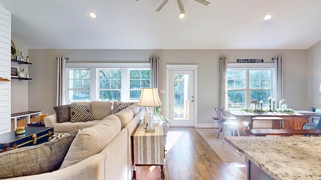 living room with a ceiling fan, wood finished floors, baseboards, recessed lighting, and vaulted ceiling